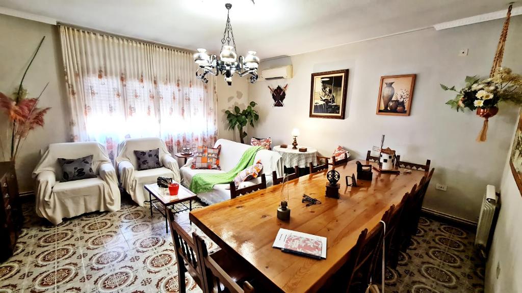 ein Wohnzimmer mit einem großen Holztisch und Stühlen in der Unterkunft La Casa de Mera a 18km de Puy du Fou in Cabañas de la Sagra