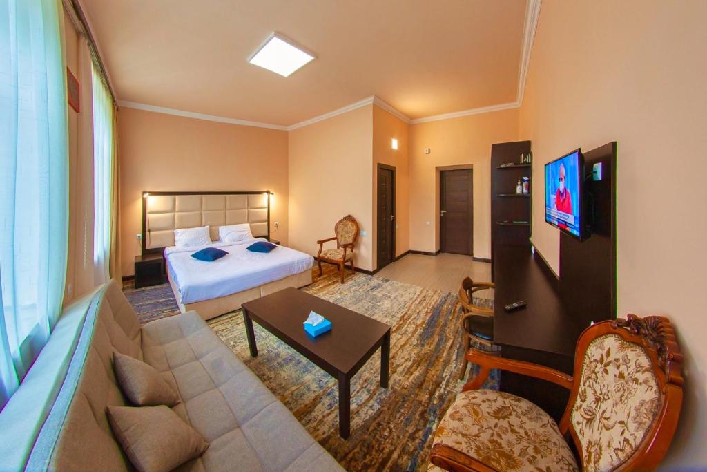 een hotelkamer met een bed en een bank bij Vanadzor Armenia Hotel in Vanadzor