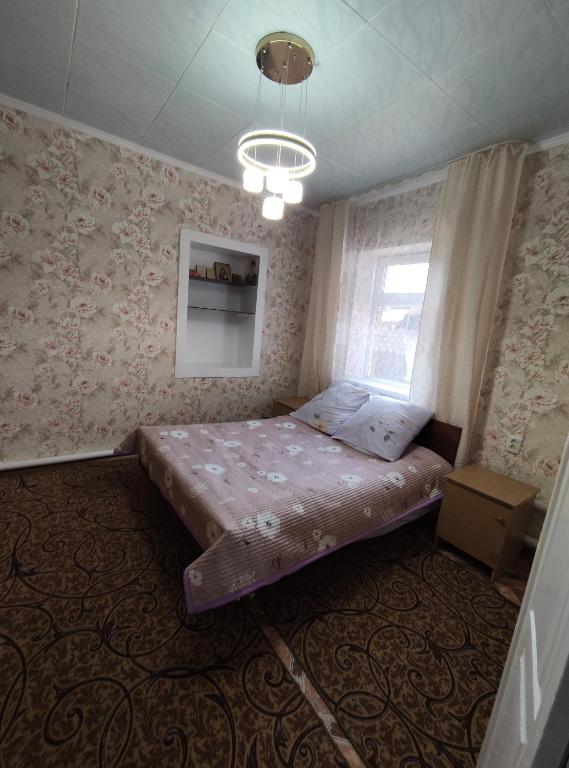 a bedroom with a bed in a room with wallpaper at Villa Valentina Issyk-Kul in Grigor'yevka
