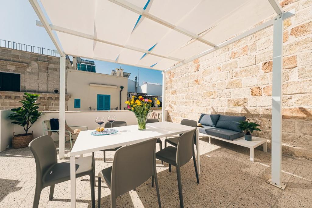 a patio with a white table and chairs at HelloApulia - La Terrazza di Don Nino in Polignano a Mare