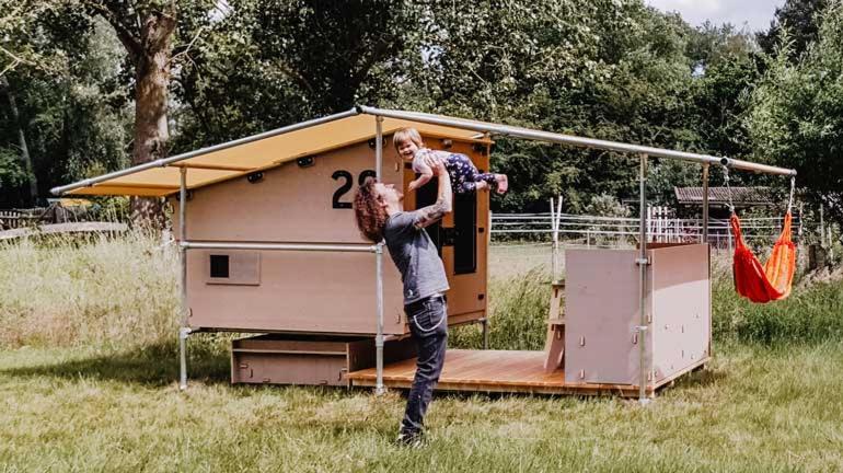 a man holding a child in front of a tiny house at destinature Dorf Südeifel in Ernzen