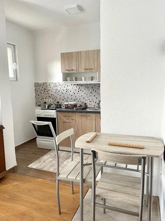 a kitchen with a table and chairs in a room at Apartment SunLight in Visoko
