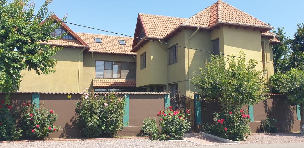 a house with a fence and flowers in front of it at Villa Mugur in 2 Mai