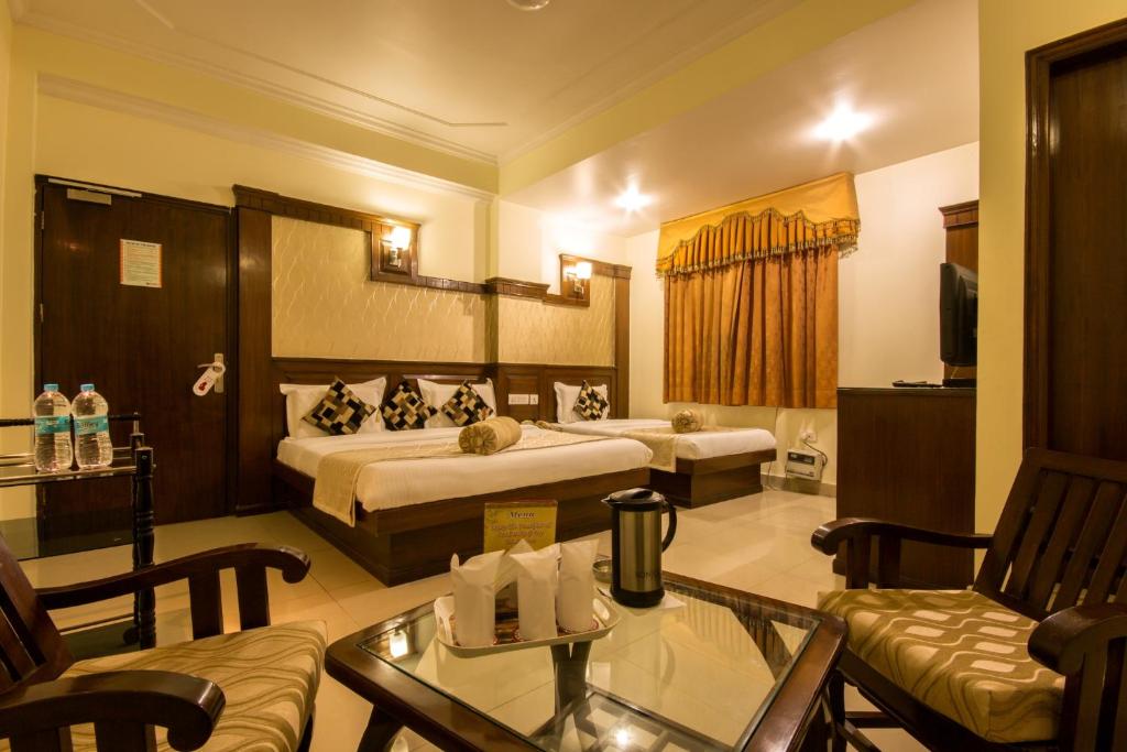 Habitación de hotel con cama y sala de estar. en Hotel Grand Park Inn en Nueva Delhi