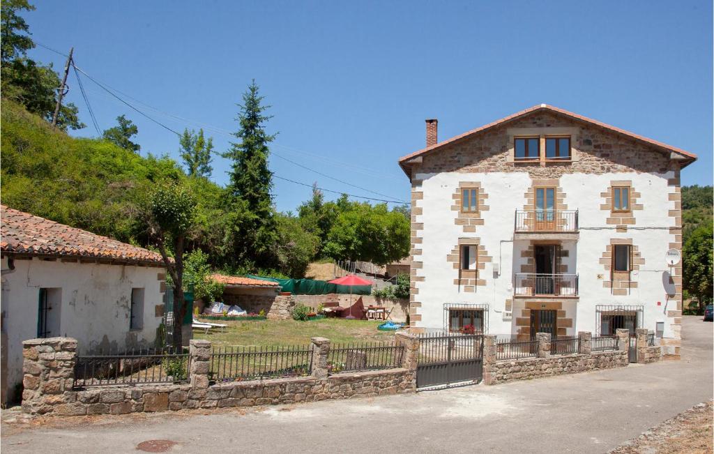 ein altes Haus mit einem Zaun davor in der Unterkunft Awesome Home In Brcena De Ebro With Kitchen in Bárcena de Ebro