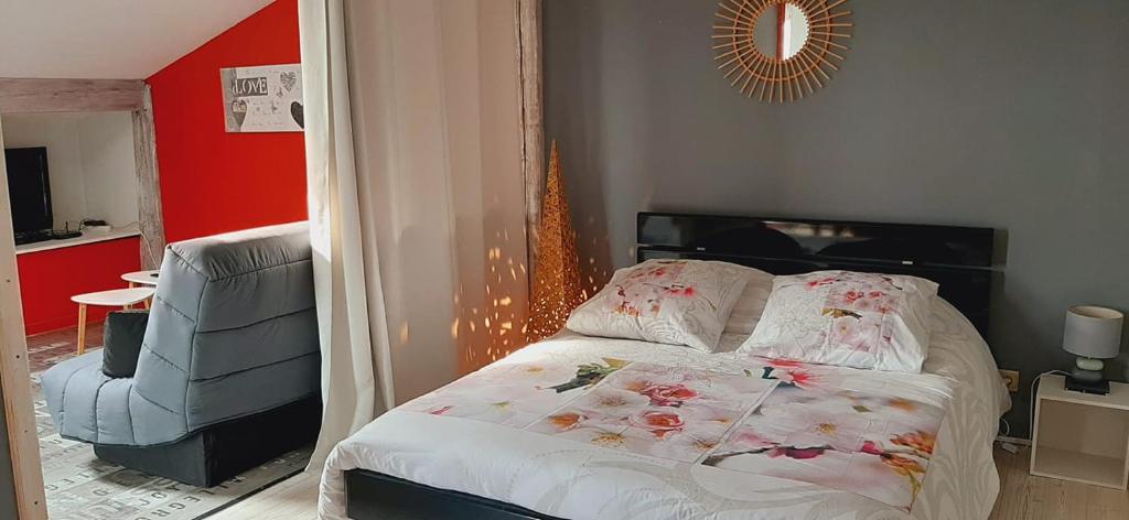 een slaapkamer met een bed en een stoel bij Appartement studio avec terrasse privatisée in Marmande