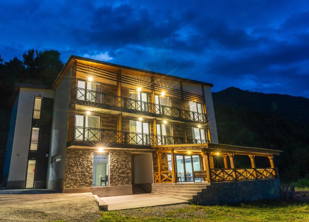 ein Haus mit beleuchteter Fassade in der Nacht in der Unterkunft Hotel Latveli Mestia in Mestia