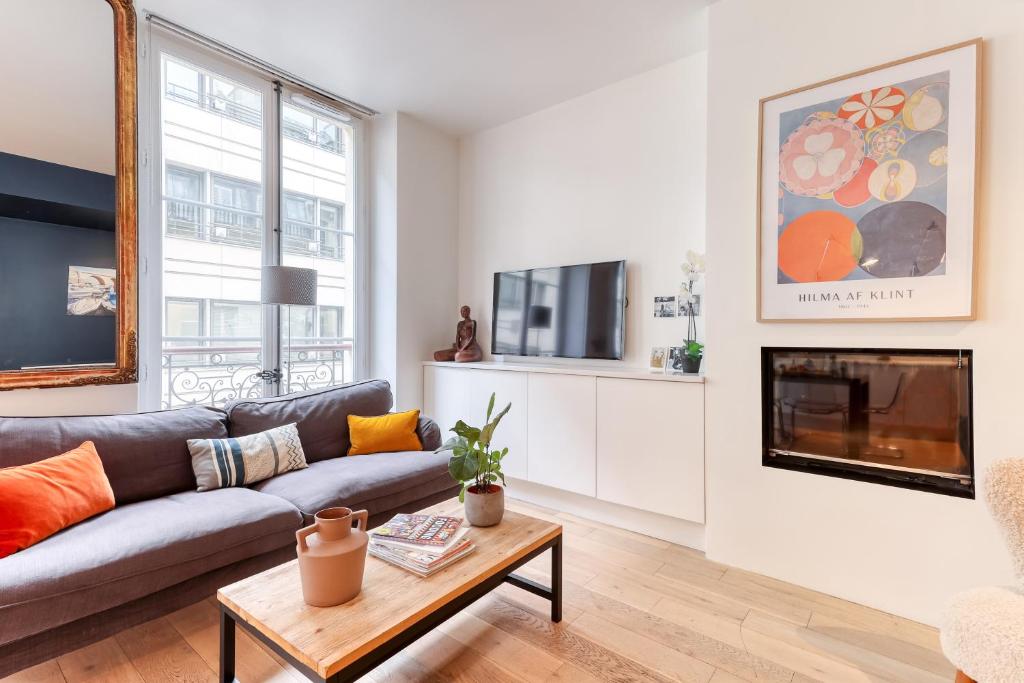 a living room with a couch and a fireplace at Gorgeous 2 Bdrs Flat in a Prime Location - Opera in Paris