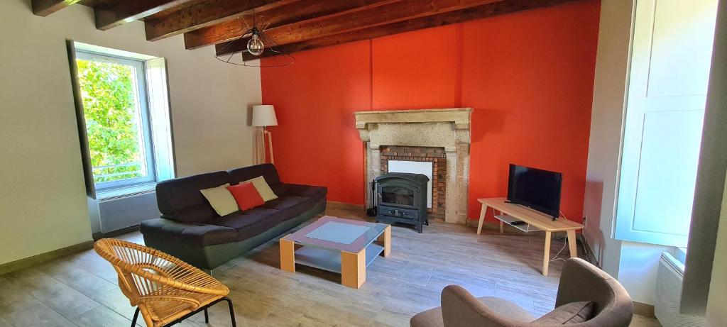 un soggiorno con divano e camino di Joli gîte chez Paulette à 10 min du Puy du Fou a Sevremont