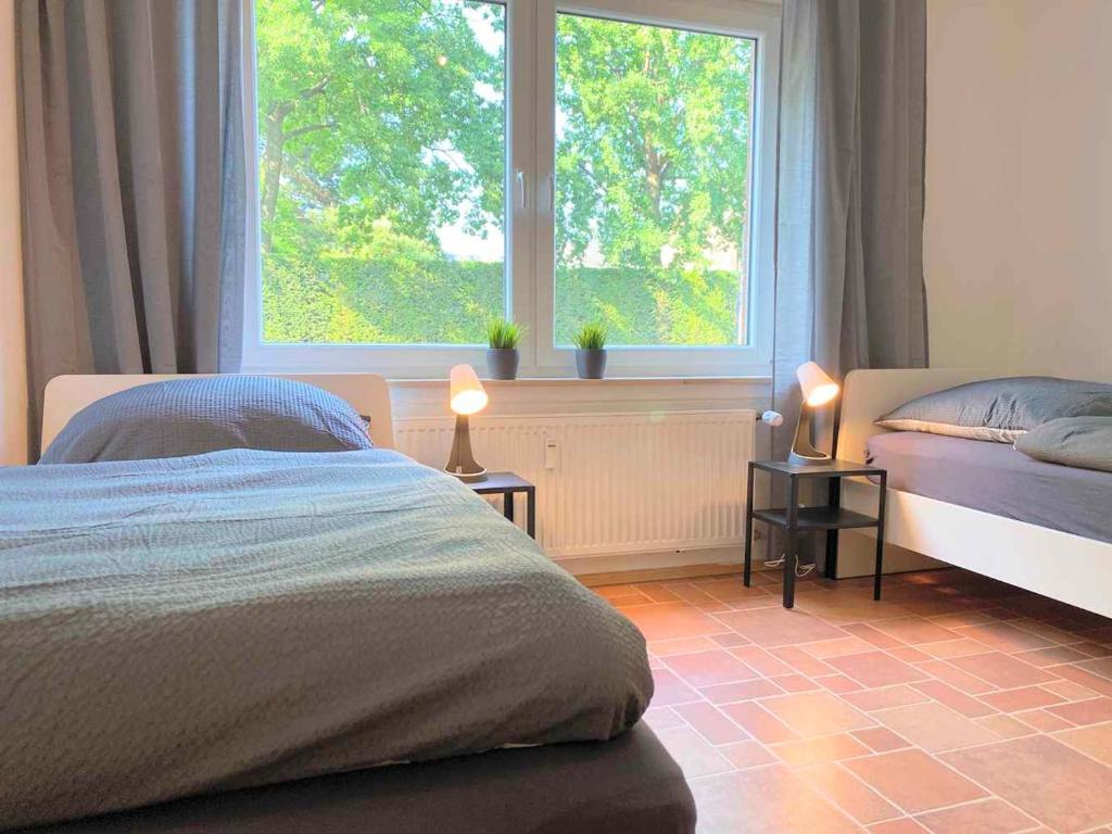 a bedroom with two beds and a large window at Spacious Apartment in Ibbenbüren in Ibbenbüren
