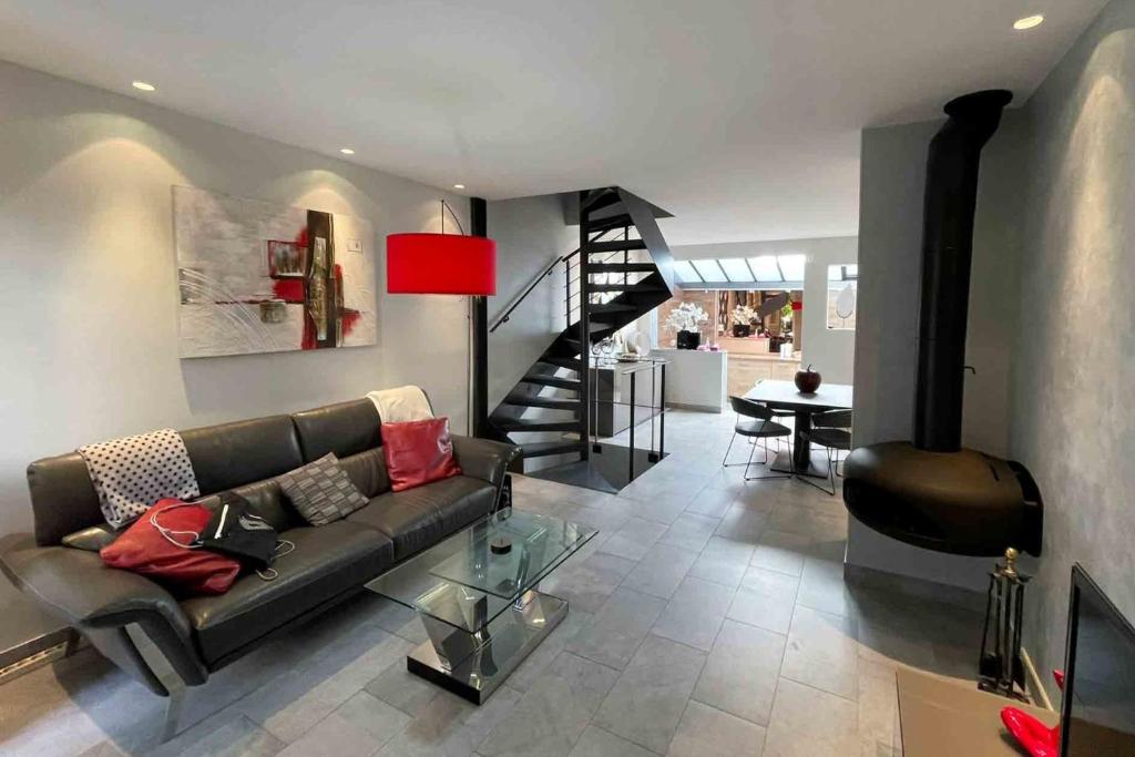 uma sala de estar com um sofá e uma escada em Charming townhouse with garden in the City of Love em Paris