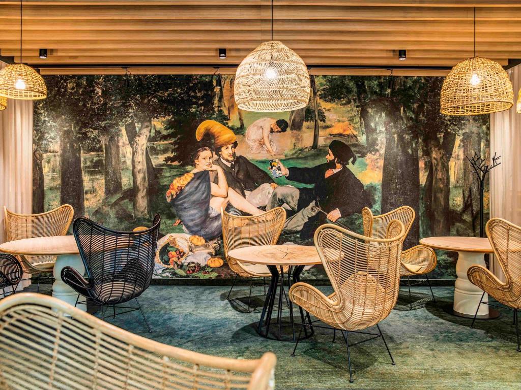 a mural in a restaurant with tables and chairs at Mercure Wrocław Centrum in Wrocław