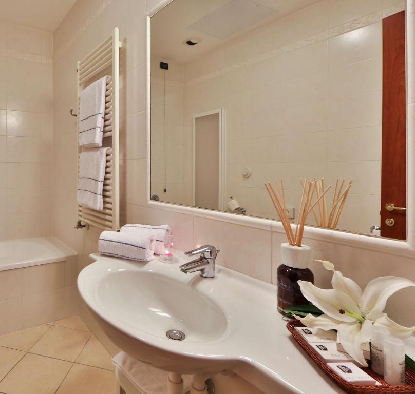 ein Bad mit einem Waschbecken und einem Spiegel in der Unterkunft Best Western Classic Hotel in Reggio nell'Emilia