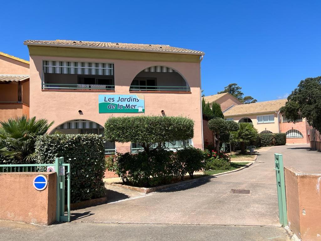 un bâtiment avec une enseigne sur le côté dans l'établissement Les jardins de la mer, à Linguizzetta