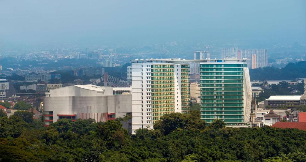 a tall white building in a city with trees at Best Western Premier La Grande Bandung in Bandung