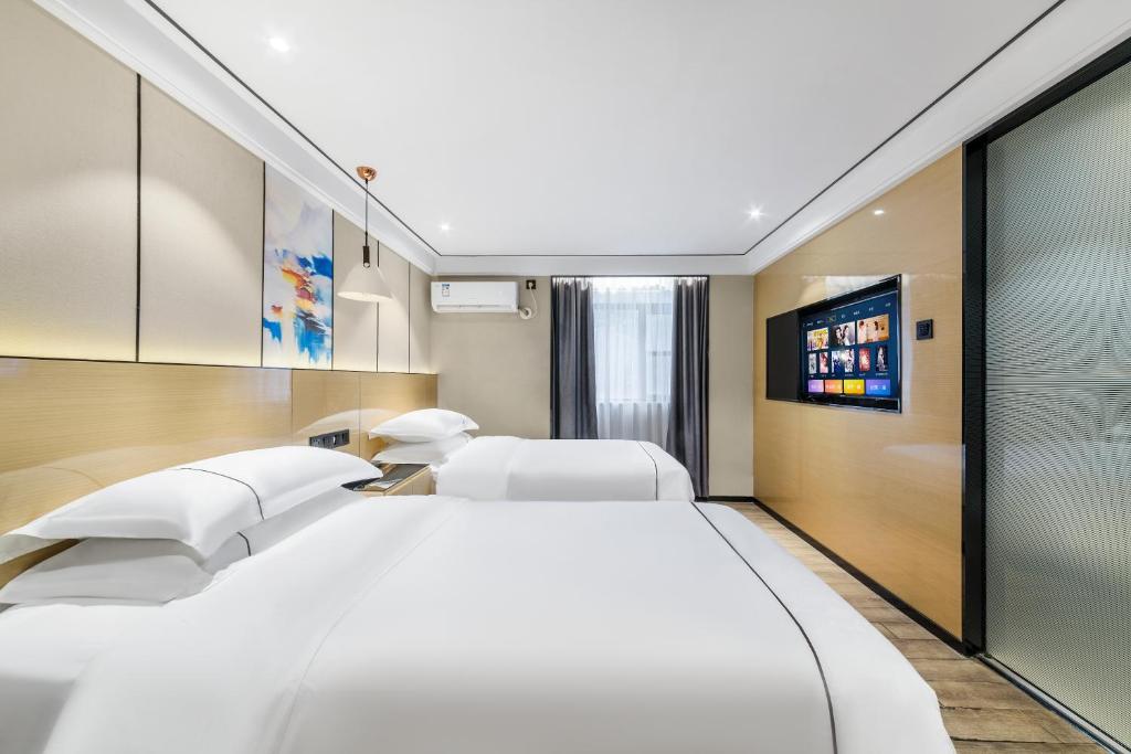 広州市にあるShangyuanHotel Quzhuang Branchの白い枕が付いた大きな白いベッドのある寝室