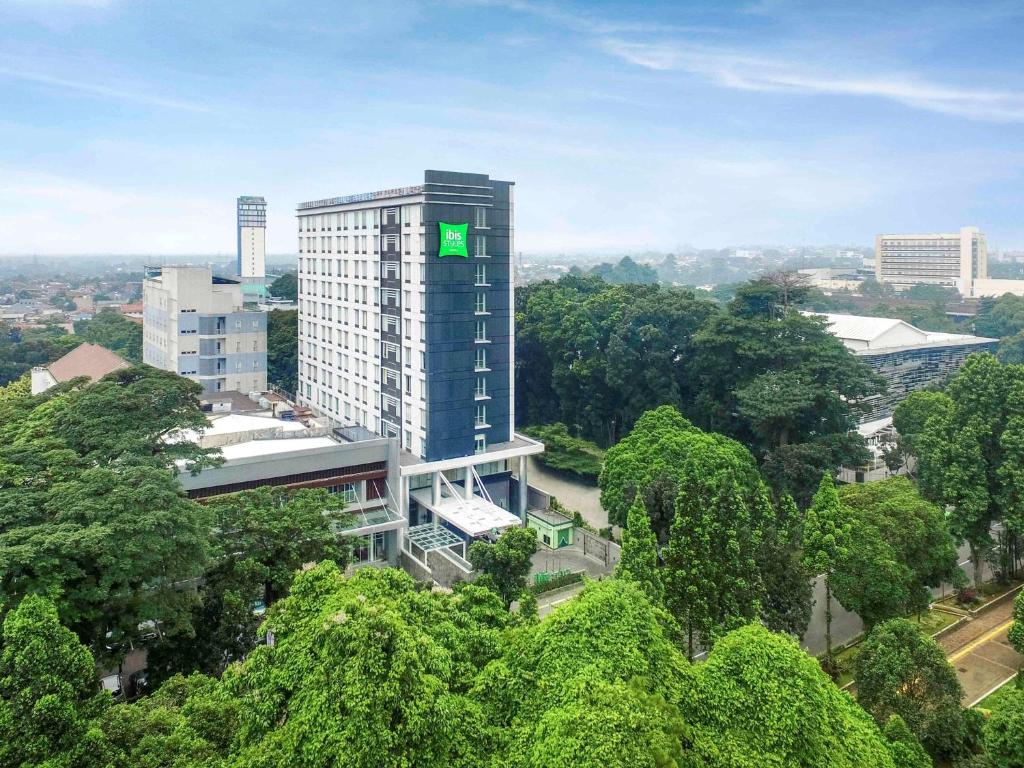 um edifício com um sinal verde no lado em ibis Styles Bogor Pajajaran em Bogor