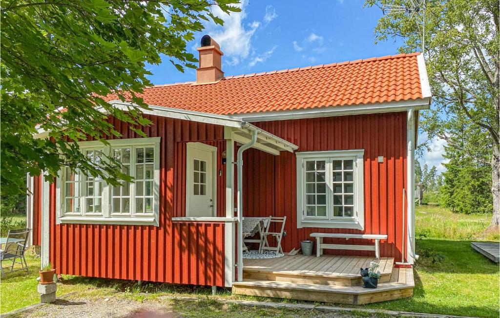 una casita roja pequeña con porche y terraza en 3 Bedroom Lovely Home In Mellerud, en Mellerud