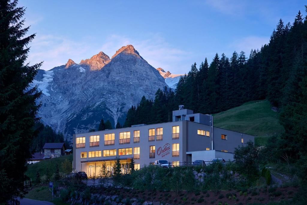 un edificio con una montagna sullo sfondo di Hotel Ortles B&B a Trafoi