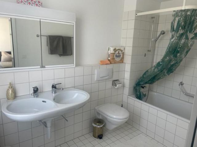 y baño con lavabo, aseo y espejo. en Appartment- Suite im Hotel Krone mit Seeblick, en Heiden