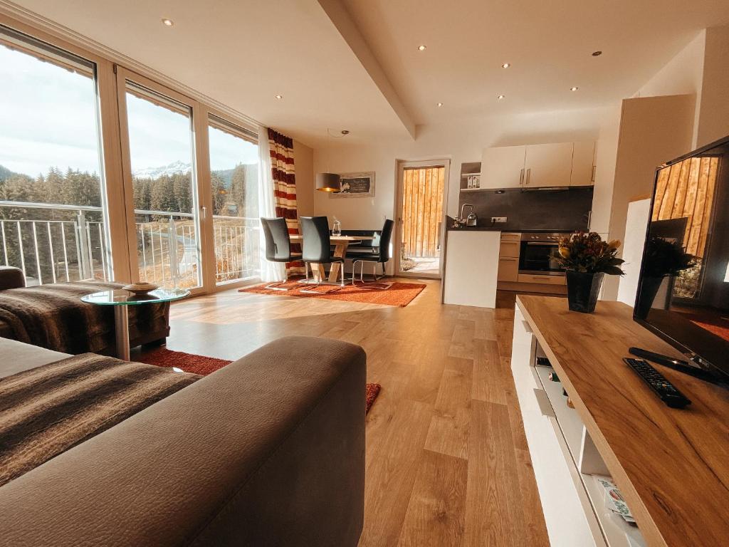 een woonkamer met een bank, een tafel en stoelen bij Patteriol Lodge in Sankt Anton am Arlberg