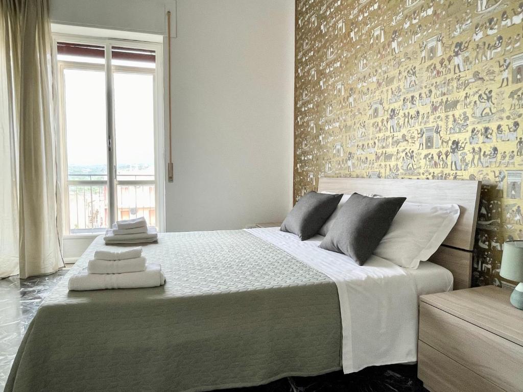 una camera con un grande letto con un muro di mattoni di Centopassi Noto B&B a Noto