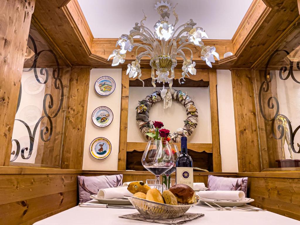 a dining room with a table with a chandelier at Hotel da Beppe Sello in Cortina dʼAmpezzo