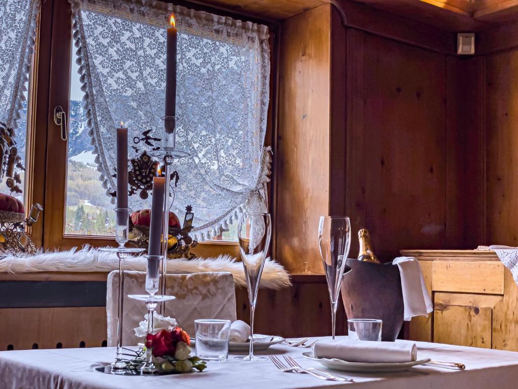 a table with a white table cloth and a window at Hotel da Beppe Sello in Cortina dʼAmpezzo