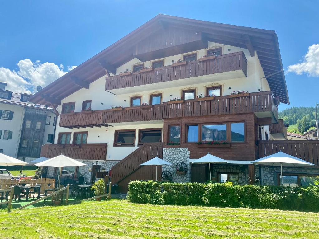 a large building with a lawn in front of it at Hotel da Beppe Sello in Cortina dʼAmpezzo