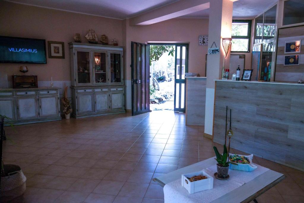 a large room with a kitchen and a lobby at Hotel L'Oleandro in Villasimius