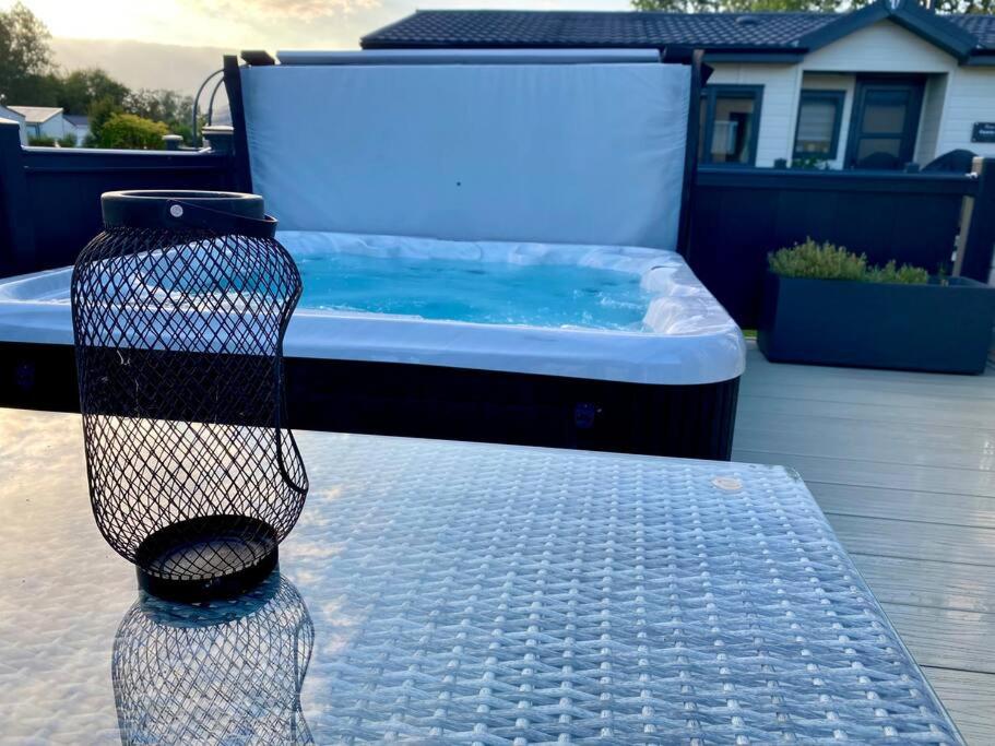 a hot tub sitting on top of a patio at Spring Lodge in South Cerney