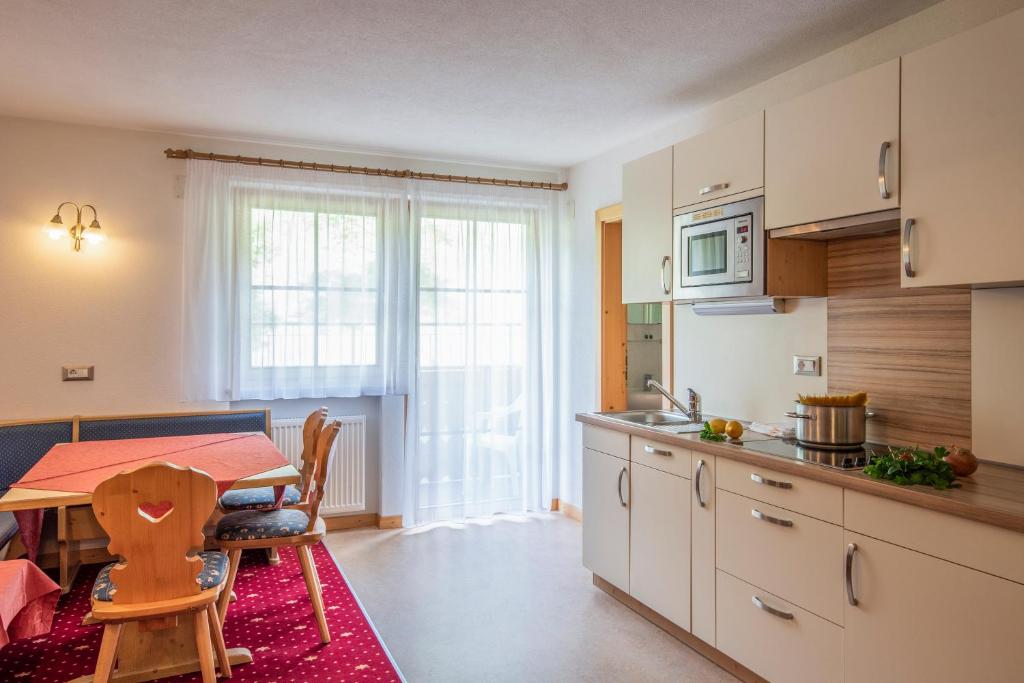 a kitchen with a table and a dining room at Residence Mühlegg in Valdaora