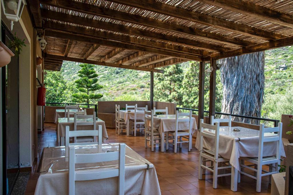 a dining room with white tables and white chairs at Hotel L'Oleandro in Villasimius