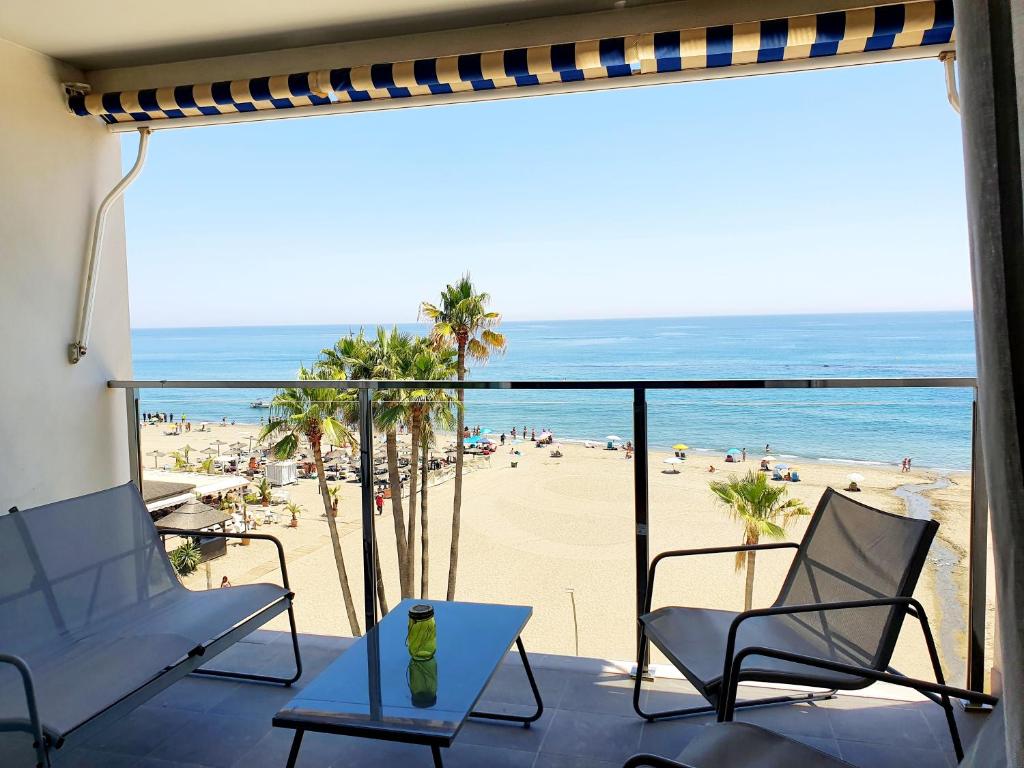 a balcony with chairs and a view of the beach at Estepona Vistamar 3 bedrooms in Estepona