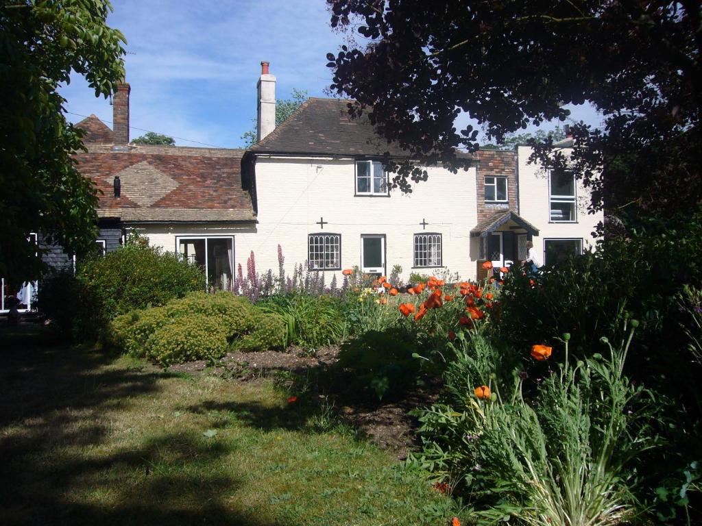 a white house with a garden in front of it at Stable Lodge B&B in Petham