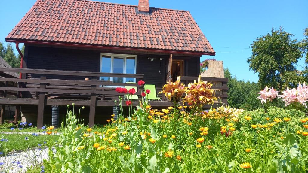 una casa con un jardín con flores delante en Raja Country House, en Koldamäe