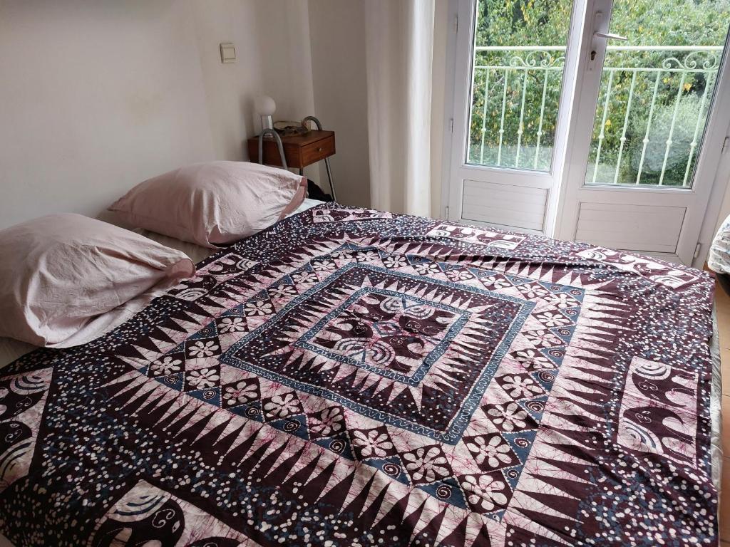 een bed met een kleurrijke quilt erop bij Robin's Lodge in Vidauban