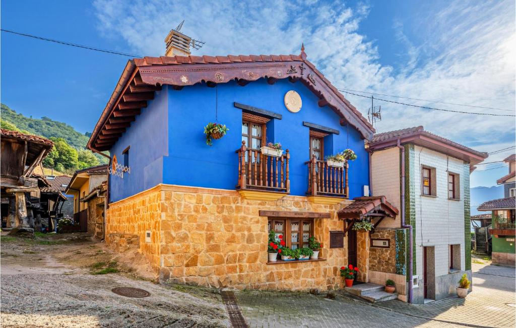 uma casa azul e amarela com uma varanda em Awesome Home In Carabanzo em Cárabanzo