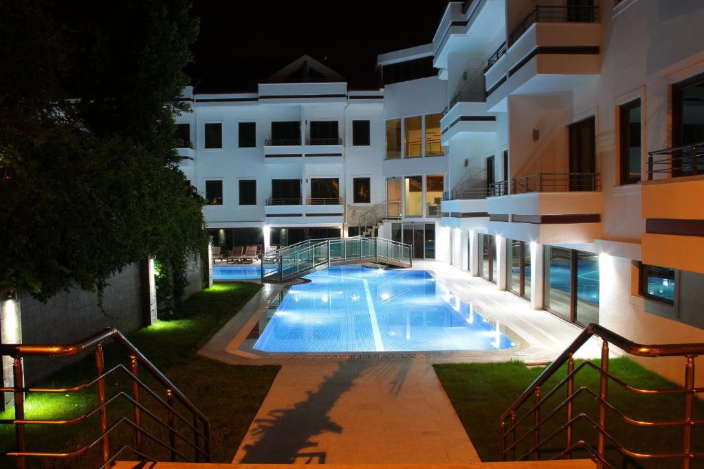 a swimming pool in front of a building at night at Malahit Exclusive City Hotel in Fethiye