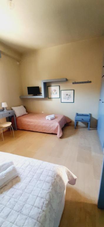 sypialnia z 2 łóżkami, biurkiem i łóżkiem w obiekcie Aggelika's Home w mieście Akrogiali