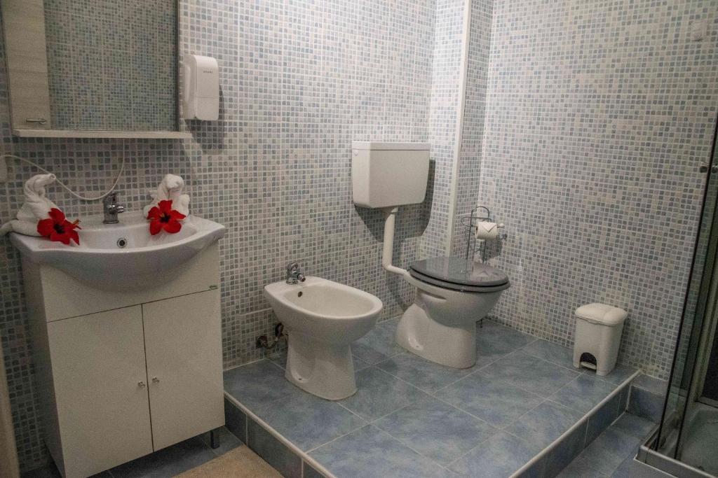 a bathroom with a toilet and a sink at Hotel L'Oleandro in Villasimius