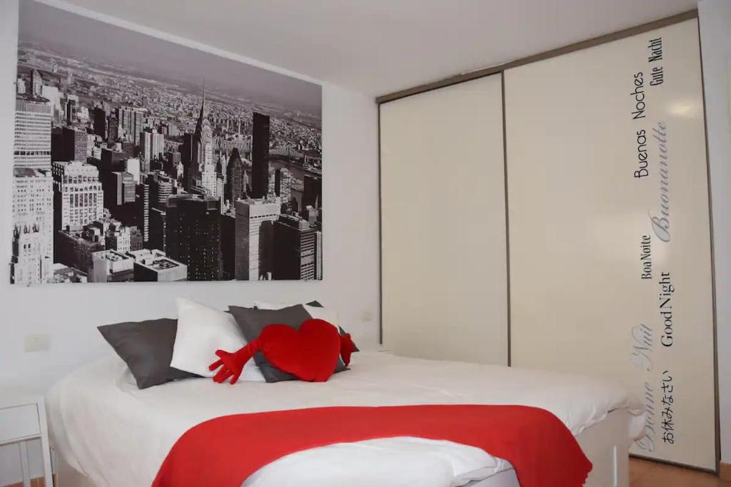 ein Schlafzimmer mit einem roten Teddybär auf einem Bett in der Unterkunft Bonito y tranquilo apartamento en Los Abrigos in Los Abrigos