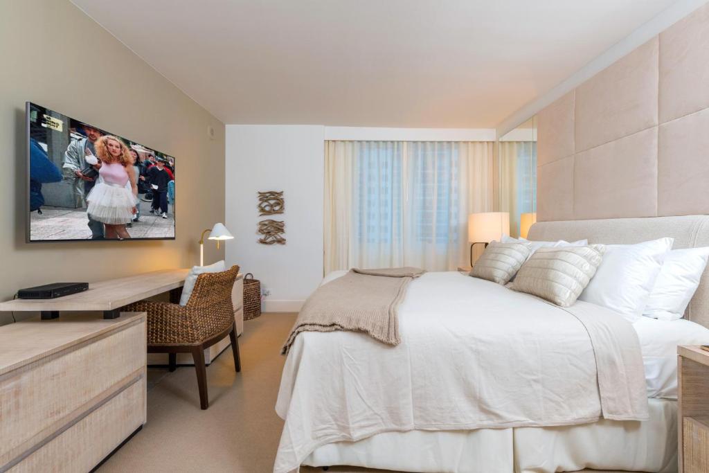 a bedroom with a large white bed and a desk at Oceanview Private Condo at 1 Hotel & Homes -1010 in Miami Beach