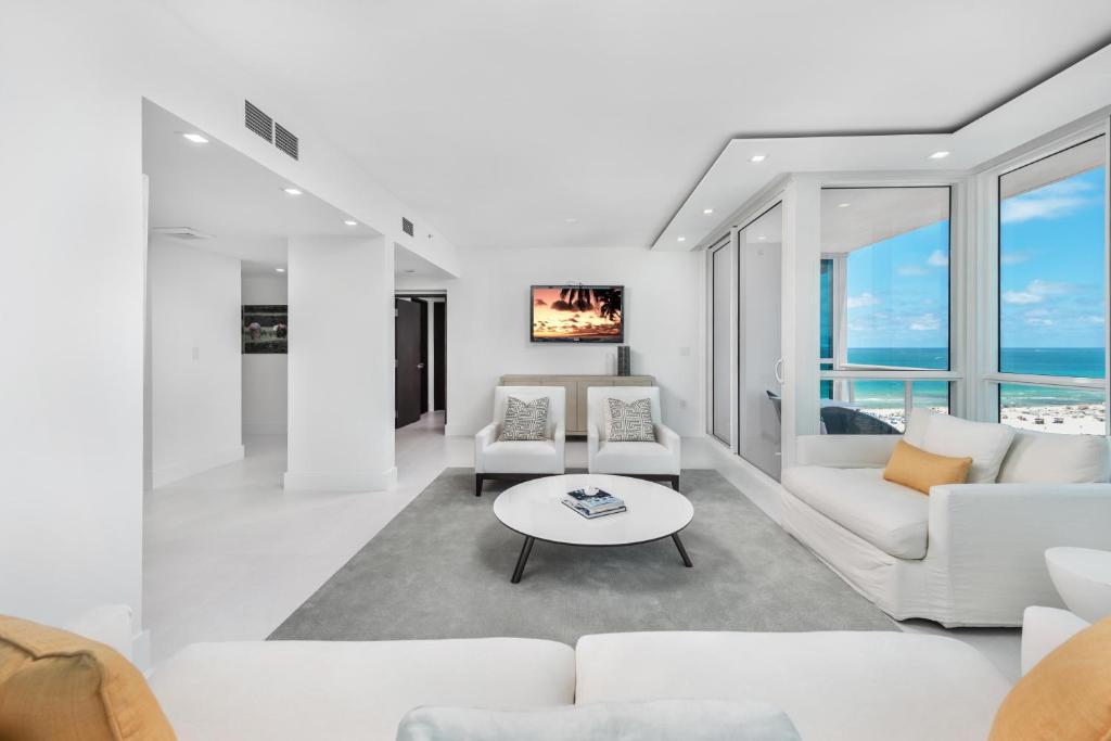 uma sala de estar com mobiliário branco e vista para o oceano em Oceanview Private Condo at The Setai -1901N2 em Miami Beach