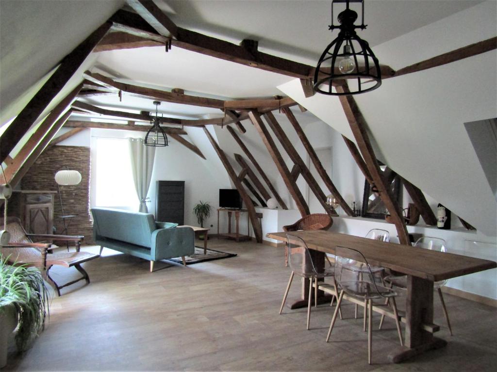 uma sala de estar com vigas de madeira e uma mesa em chez LISON, HEBERGEMENT DE CHARME EN MADIRAN 