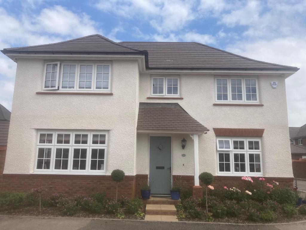 a white house with a black roof at Mill Meadows in Portskewett