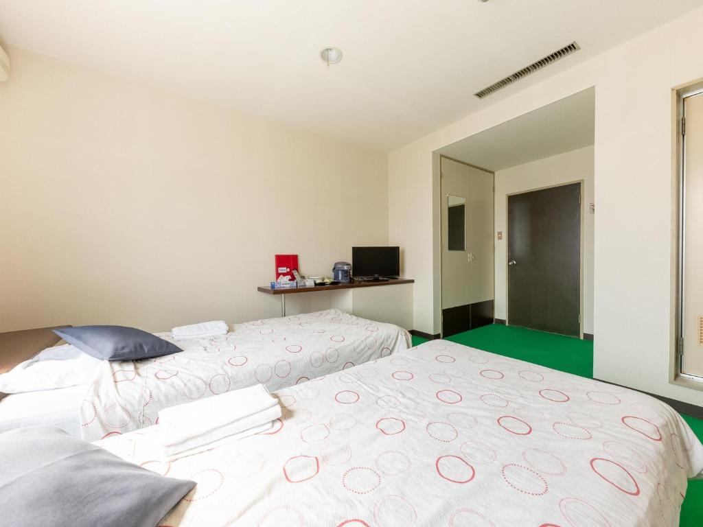 Postel nebo postele na pokoji v ubytování Tabist Business Hotel Chitose Kashiwazaki