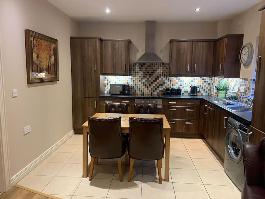 a kitchen with a wooden table and two chairs at Sperrin View Apartment (Ground Floor) in Draperstown