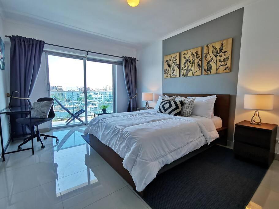 a bedroom with a large bed and a large window at New Condo Rooftop Pool. Gym. Discounted rate in Santo Domingo
