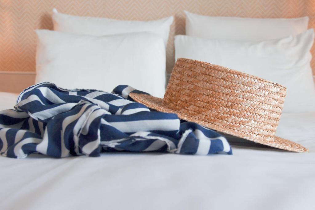 a straw hat sitting on top of a bed at Novotel Monte-Carlo in Monte Carlo